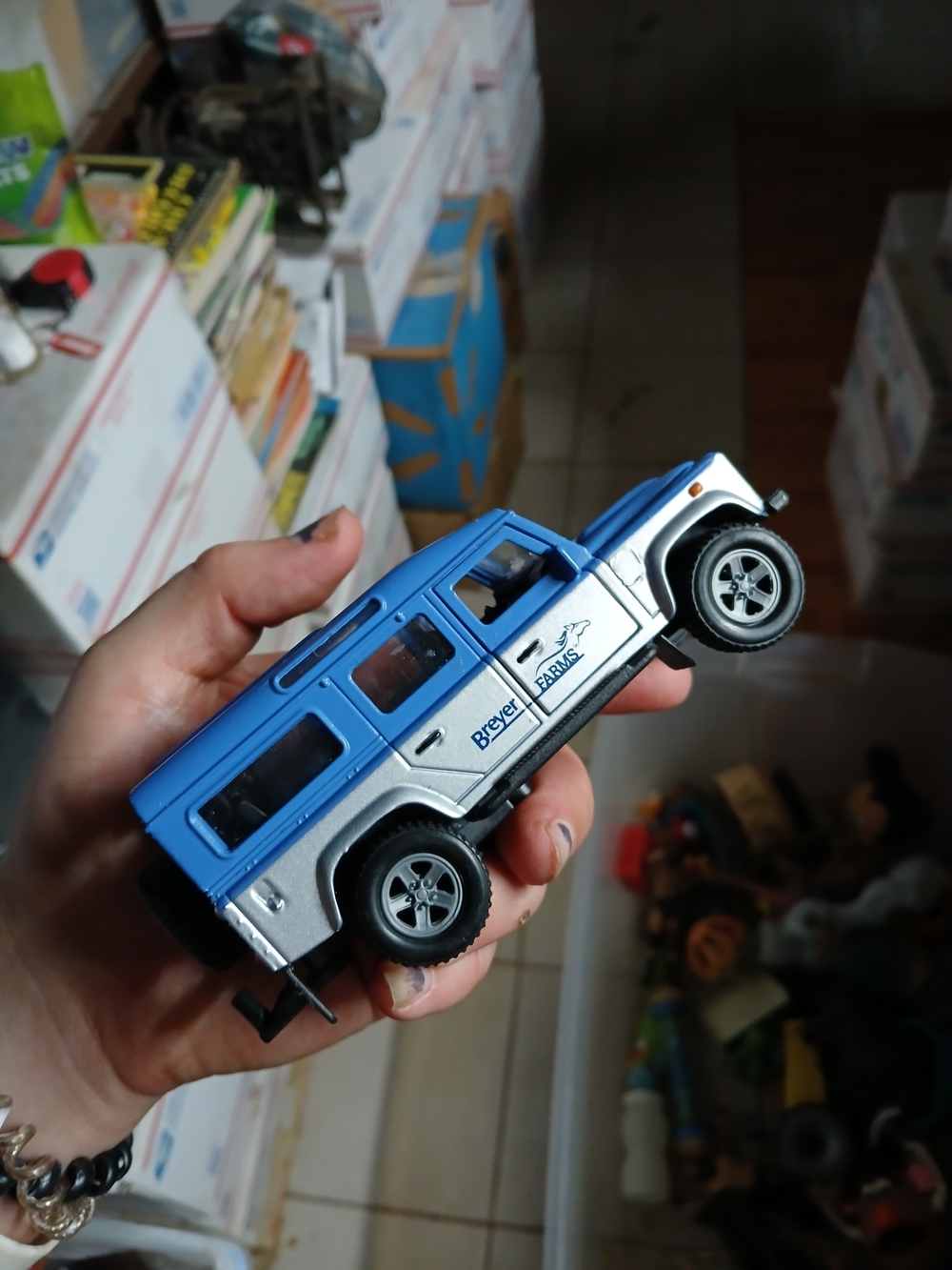 blue and silver Breyer Farms Land Rover Defender toy vehicle